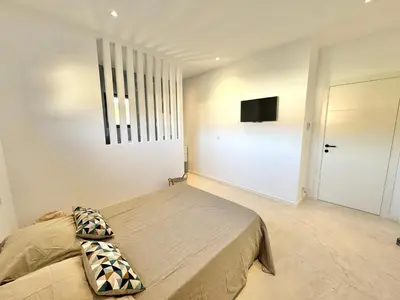 a bedroom with a bed and a flat screen tv at Villa Porto-Vecchio avec piscine in Lecci