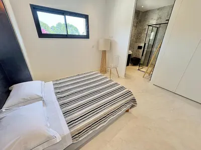 a bedroom with a bed with a window on the wall at Villa Porto-Vecchio avec piscine in Lecci