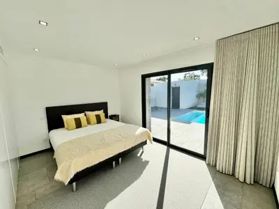 a bedroom with a bed and a sliding glass door at Villa Porto- Vecchio avec piscine 8 pers in Lecci