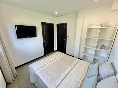 a bedroom with a bed and a flat screen tv at Villa Porto- Vecchio avec piscine 8 pers in Lecci
