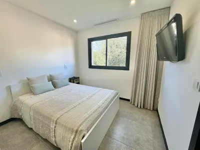 a bedroom with a bed with a television and a window at Villa Porto- Vecchio avec piscine 8 pers in Lecci