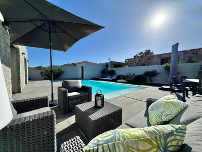 a patio with chairs and an umbrella and a pool at Villa Porto- Vecchio avec piscine 8 pers in Lecci