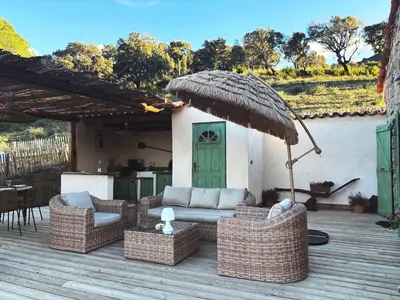 a patio with wicker furniture and an umbrella at Tradition Corse & Modernité I Caseddi di Barabè in Granace