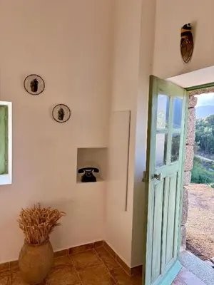 a room with a door and a vase on the wall at Tradition Corse & Modernité I Caseddi di Barabè in Granace