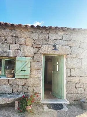 a stone building with a green door and a window at Tradition Corse & Modernité I Caseddi di Barabè in Granace