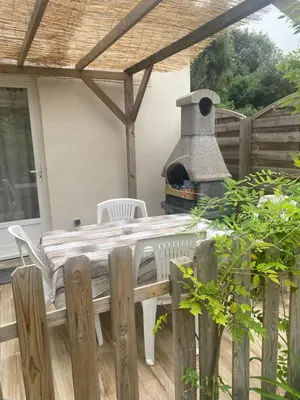 a patio with a table and an outdoor oven at Bonifacio tranquillité paradis in SantʼAmanza