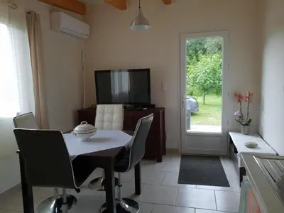a dining room with a table and chairs and a television at Bonifacio tranquillité paradis in SantʼAmanza