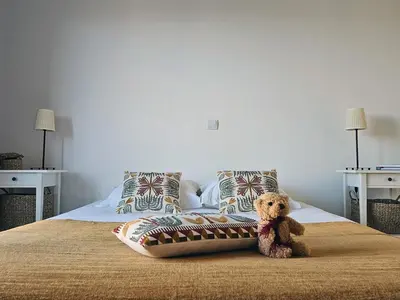 a teddy bear sitting on top of a bed at Villa de standing Vista - Domaine Romella - Piscine - Vue Lac de Padula in Oletta