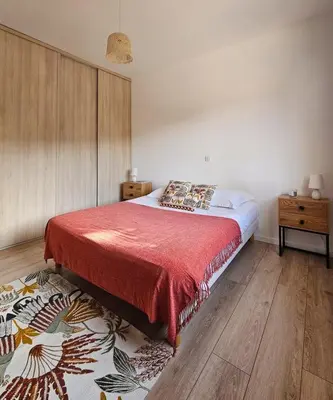 a bedroom with a large bed with a red blanket at Villa de standing Vista - Domaine Romella - Piscine - Vue Lac de Padula in Oletta