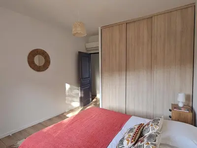 a bedroom with a bed and a wooden wall at Villa de standing Vista - Domaine Romella - Piscine - Vue Lac de Padula in Oletta