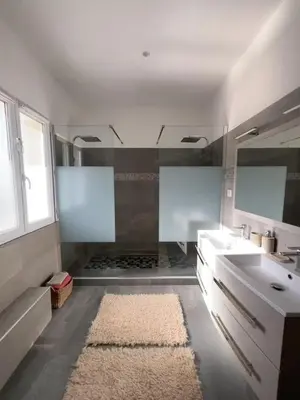 a bathroom with a sink and a mirror and a rug at Villa de standing Vista - Domaine Romella - Piscine - Vue Lac de Padula in Oletta