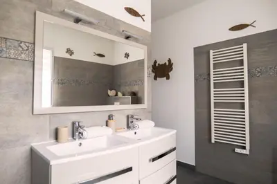 a bathroom with two sinks and a mirror at Villa de standing Vista - Domaine Romella - Piscine - Vue Lac de Padula in Oletta