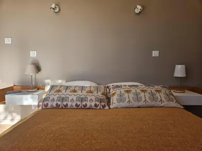 a bedroom with a bed with two pillows and two lamps at Villa de standing Fiurenza - Domaine Romella - Piscine - Proche Saint-Florent in Oletta