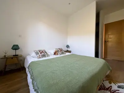 a bedroom with a large bed with a green blanket at Villa de standing Fiurenza - Domaine Romella - Piscine - Proche Saint-Florent in Oletta