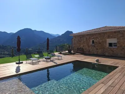 a swimming pool with chairs and a house at Domaine Le Chemin des Oliviers jusqu'à 12 personnes piscine et ou jacuzzi in Ocana