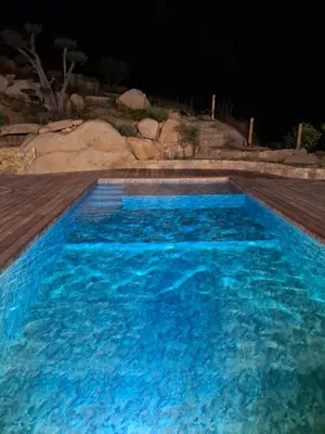 a swimming pool with blue water at night at Domaine Le Chemin des Oliviers jusqu'à 12 personnes piscine et ou jacuzzi in Ocana