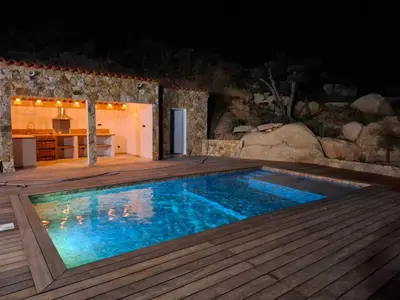 a swimming pool with a wooden deck and a kitchen at Domaine Le Chemin des Oliviers jusqu'à 12 personnes piscine et ou jacuzzi in Ocana