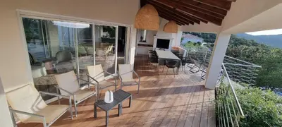 a balcony of a house with chairs and a table at Maison de standing avec piscine vue mer Corse du sud Pozzaccio, Portigliolo 2 à 6 personnes 3 chambres in Coti-Chiavari