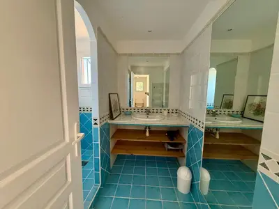 a bathroom with two sinks and two mirrors at Villa vue mer, spacieuse, piscine privée in Sari Solenzara