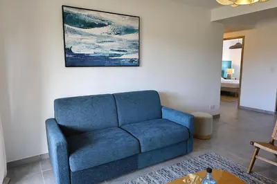 a blue couch sitting in a living room at Villa Tranquille - Maison 4 étoiles 2 Chambres Bonifacio in Bonifacio