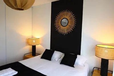 a bedroom with a bed with two lamps and a mirror at Villa Tranquille - Maison 4 étoiles 2 Chambres Bonifacio in Bonifacio