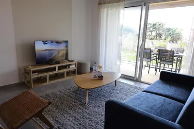 a living room with a blue couch and a table at Villa Tranquille - Maison 4 étoiles 2 Chambres Bonifacio in Bonifacio