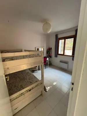 a room with two bunk beds and a desk at Maison à 50 m de la plage, 10 personnes, 5 chambres en corse du sud, in Coti-Chiavari