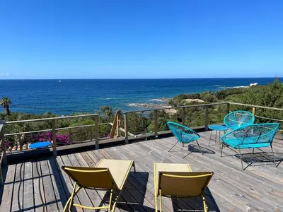 a deck with chairs and a view of the ocean at Maison à 50 m de la plage, 10 personnes, 5 chambres en corse du sud, in Coti-Chiavari