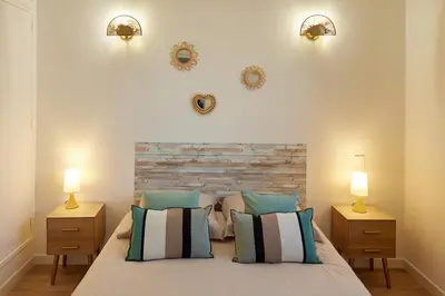 a bedroom with a bed with two night stands and two lamps at Coquet T2 pres des plages in Propriano