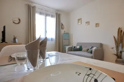 a table with a white plate and glasses on it at Coquet T2 pres des plages in Propriano