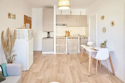 a kitchen with a white refrigerator and a table at Coquet T2 pres des plages in Propriano