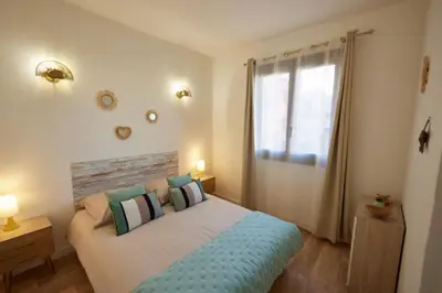 a bedroom with a large bed and a window at Coquet T2 pres des plages in Propriano