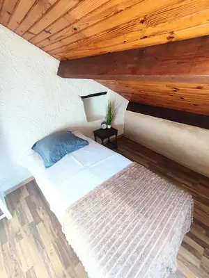 a bedroom with a large white bed with red pillows at Maison typique de village Corse , 10 min aéroport et de la mer in Prunelli-di-Casacconi
