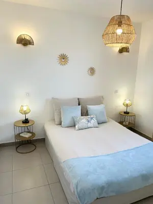 a bedroom with a large bed with two lamps at Joli T2 petite vue mer in Propriano