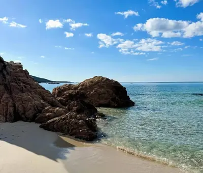 a beach with some rocks and the ocean at Joli T2 petite vue mer in Propriano