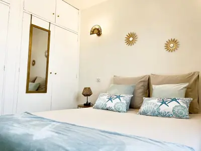 a bedroom with a large white bed with blue pillows at Joli T2 petite vue mer in Propriano