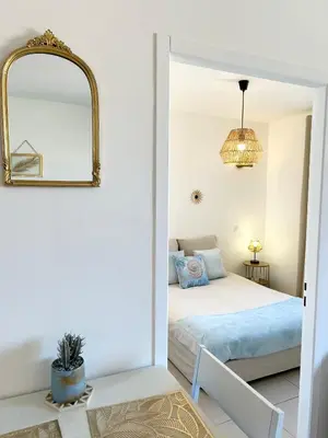 a bedroom with a bed and a mirror at Joli T2 petite vue mer in Propriano