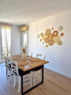 a dining room with a wooden table and chairs at Appartement Ajaccio vue mer in Ajaccio