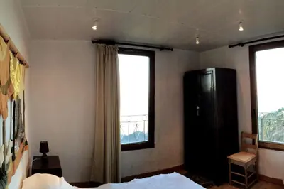 a bedroom with a bed and a large window at House between the sea and the mountain in San-Giovanni-di-Moriani