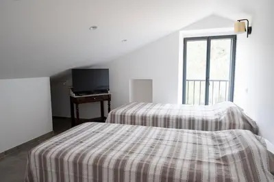 a white room with two beds and a window at Noscia Nivaledda - Stone house, with pool in Porto-Vecchio