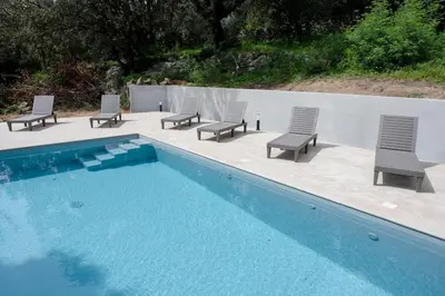a group of chairs sitting next to a swimming pool at Noscia Nivaledda - Stone house, with pool in Porto-Vecchio