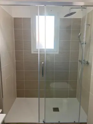 a shower with a glass door in a bathroom at E casette in Oletta