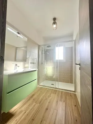 a bathroom with a shower and a sink and a glass shower door at E casette in Oletta