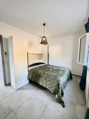 a bedroom with a bed and a pendant light at E casette in Oletta