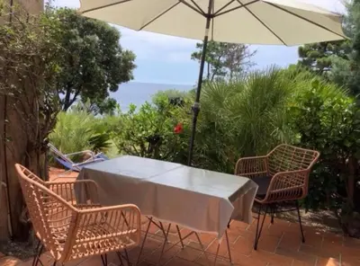 a table and chairs with an umbrella on a patio at Secret creek in Zonza