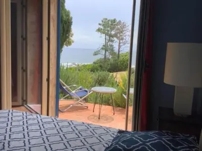 a bedroom with a bed and a view of the ocean at Secret creek in Zonza