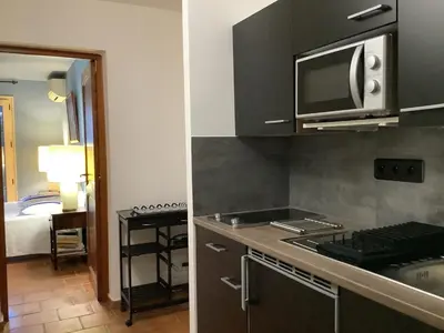 a kitchen with a microwave and a stove top oven at Secret creek in Zonza
