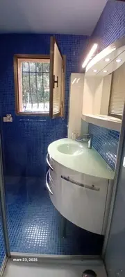 a bathroom with a sink and a window and a mirror at Secret creek in Zonza