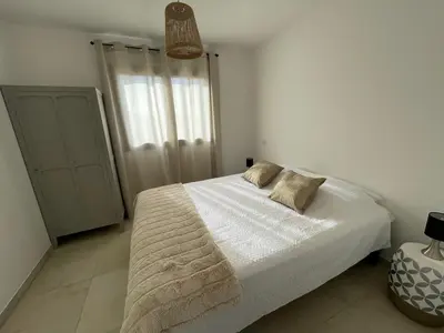 a bedroom with a white bed with two pillows on it at Magnifique appartement T2 in Cuttoli-Corticchiato