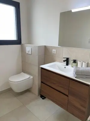 a bathroom with a sink and a toilet and a mirror at Magnifique appartement T2 in Cuttoli-Corticchiato